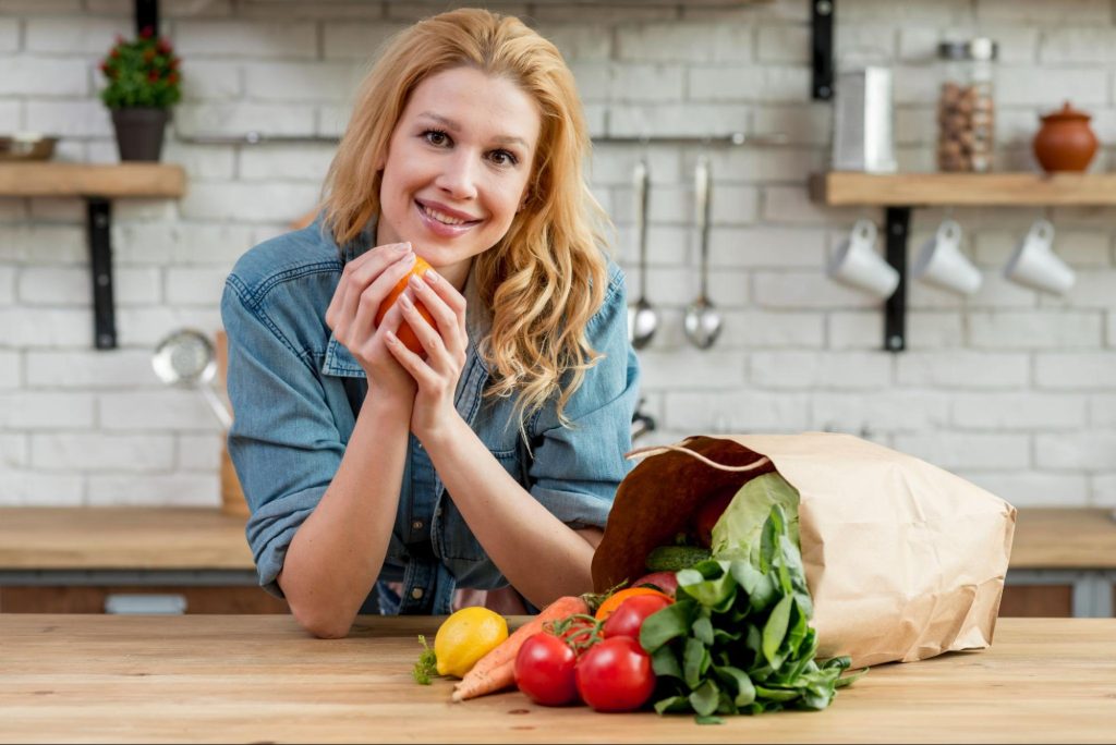 Жена с торба продукти за здравословно хранене.